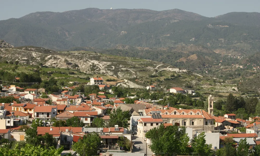 The village of Omodos among vineyards, with the Troodos mountains behind