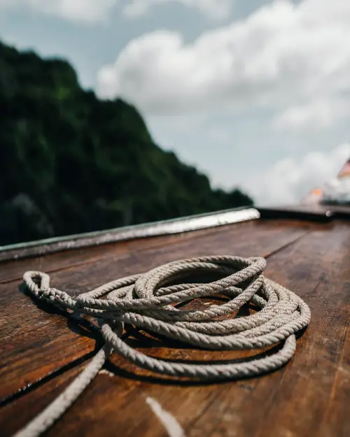 A rope coiled on a varnished wooden deck