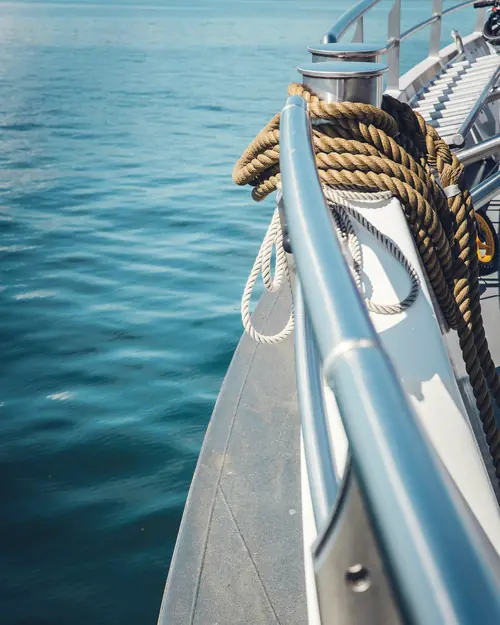 A coiled mooring line on the bow rail, open sea beyond