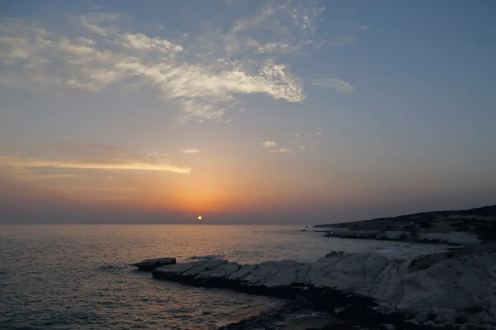 The sun setting over the sea beyond the white rocks east of Limassol