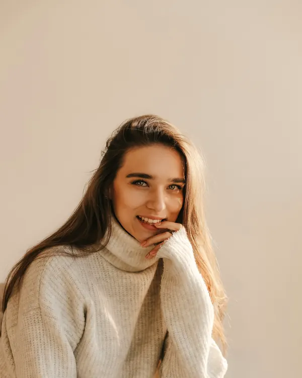 Portrait of Marina, smiling, in a cream knit jumper