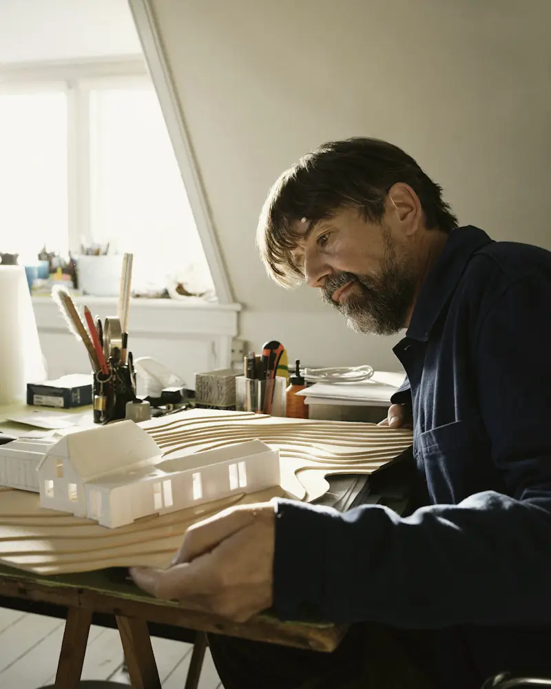 Portrait of Marios Ioannou at his desk with a model